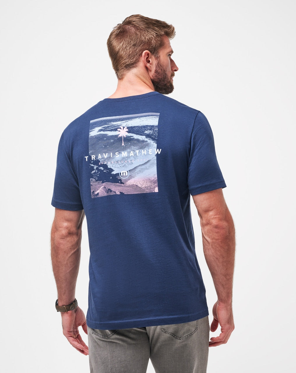 Blue t-shirt with wave graphic and travis mathew logo.