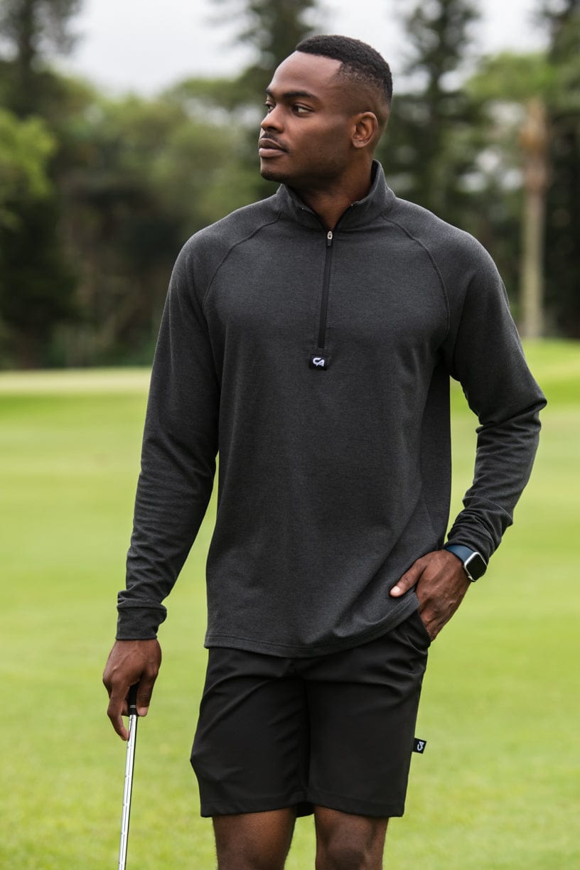 Black golf pullover with half-zip design and textured fabric.